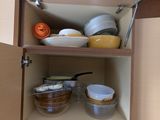 a cabinet with a lot of dishes and bowls in it