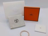 un bracelet orange avec un fermoir doré et une boîte blanche