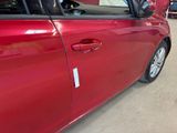 a red car parked in a showroom with its door open