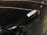 a black car with a sticker on it parked in a parking lot