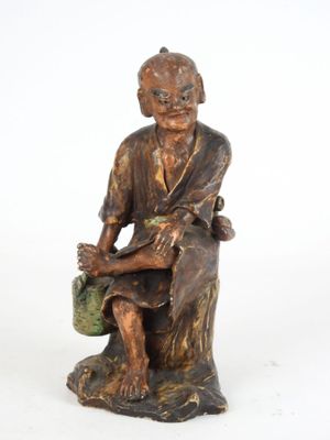 l'image d'une statue d'un homme assis sur un rocher