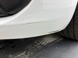 a close up of a car ' s front bumper and tire