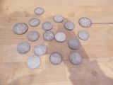 un tas de pièces de monnaie par terre, à côté de l'ombre d'une personne