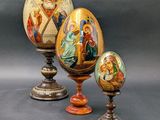 trois œufs décoratifs ornés de motifs religieux, posés sur une table