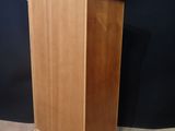 a wooden cabinet sitting on top of a carpeted floor next to a black wall