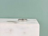 un gros plan d'une bague en diamant posée sur un bloc de marbre