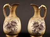 pair of antique vases with floral designs on them against a black background