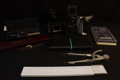 a desk with a keyboard, a mouse, a pair of scissors and a book