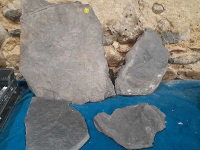 three large rocks sitting on a blue cloth next to a cell phone