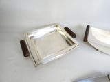 deux plateaux en argent et un couteau posés sur une table blanche