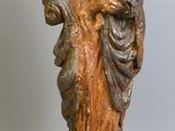 statue of a woman holding a child in her arms on a wooden base