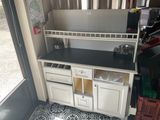 une cuisine avec un plan de travail noir et des placards blancs