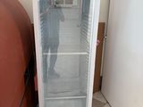 a refrigerator that is sitting next to a trash can