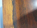 a close up of a clock on a wooden table