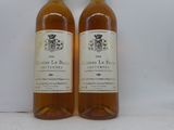 deux bouteilles de vin posées l'une à côté de l'autre sur une surface blanche