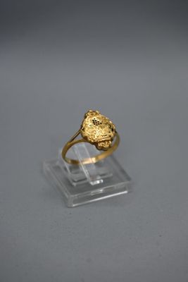 Gros plan sur une bague en or ornée d'une fleur