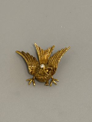 une broche en forme d'oiseau en or, avec un diamant dans le bec