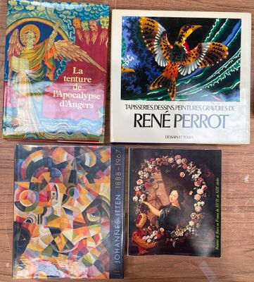 quatre livres posés sur une table en bois sur laquelle se trouve un oiseau et un autre oiseau