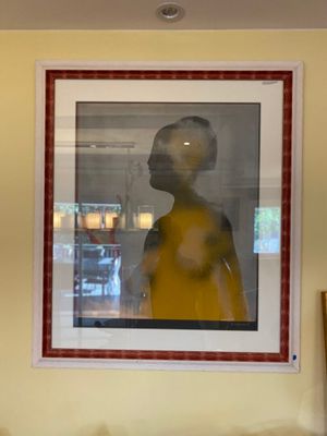 a picture of a woman in a yellow dress hanging on a wall