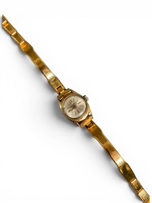 une image d'une montre-bracelet en or sur une surface blanche