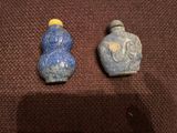 deux bouteilles bleues et jaunes posées sur une surface marron