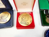 three medals sitting in a red box on a table