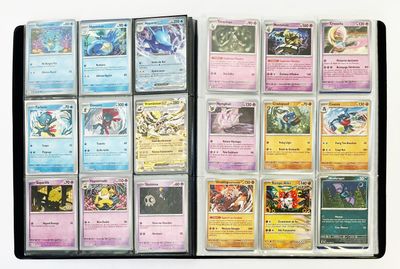 beaucoup de cartes Pokémon rangées dans un classeur posé sur la table