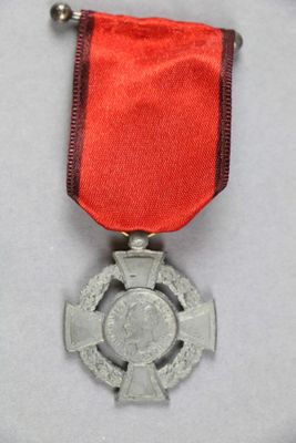 une image représentant une médaille ornée d'un ruban rouge et d'une croix