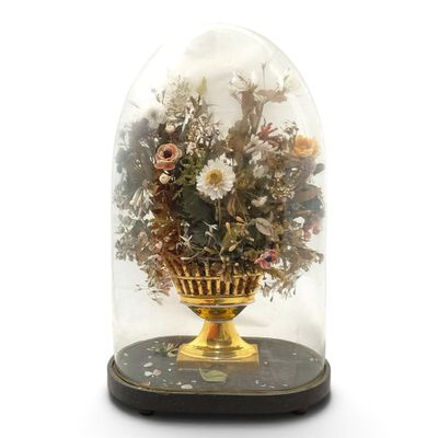 une cloche en verre contenant des fleurs, posée sur une table