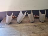 five vases sitting on a wooden table with a white wall behind them