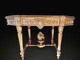 une table richement sculptée sur laquelle est posé un vase