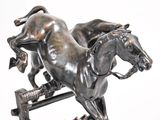 a statue of a horse and a dog on a stand