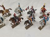 many figurines of soldiers on display on a white surface