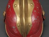 an old helmet with a red and gold design on it