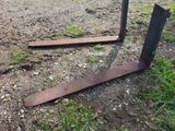 two pieces of metal sitting on the ground next to a dirt road