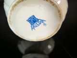 a white cup with a blue design on it on a table