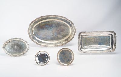 several pieces of silver are arranged on a white surface