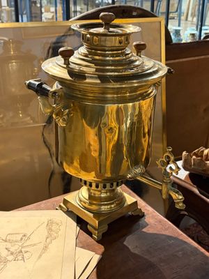une cafetière en or posée sur une table en bois