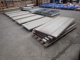 de nombreuses pièces métalliques empilées sur des palettes dans un entrepôt