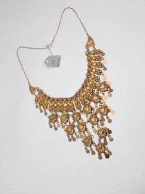un gros plan d'un collier en or orné de pièces de monnaie
