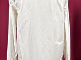 white shirt on a mannequin stand against a red background