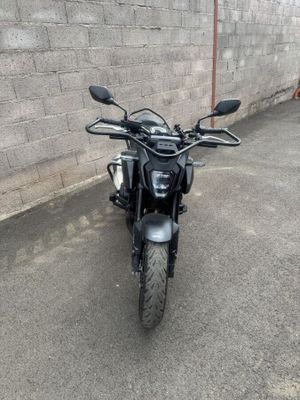 une moto noire garée devant un mur de briques