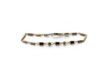 un gros plan d'un bracelet en or orné de perles sur fond blanc