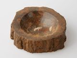 a wooden bowl on a white surface with a white background
