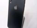 a black iphone sitting on a stand on a white surface