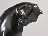a black statue of a cat with a collar on it ' s neck