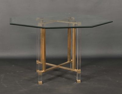 a glass table with gold legs and a clear glass top