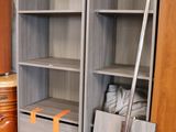 a tall bookcase with several shelves in a room