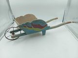 a small wooden toy wheelbarrow with a bird on it