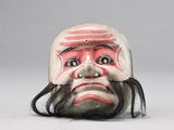 un petit masque sur lequel est peint le visage d'un homme